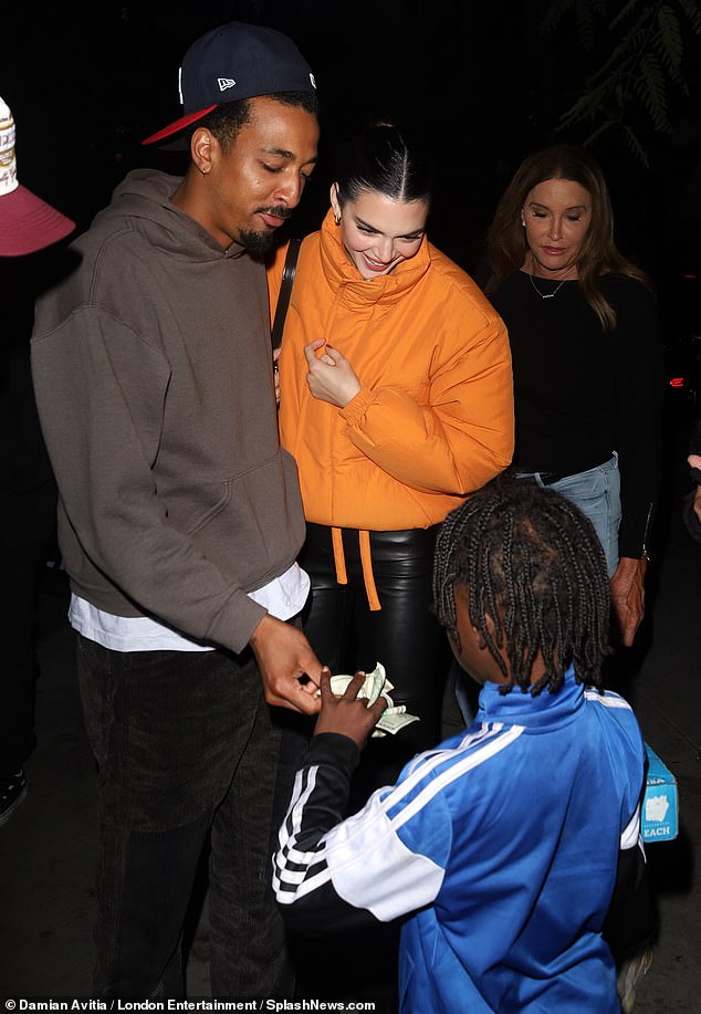 Sweet tooth: She was joined by her friend Travis 'Taco' Bennett. The two were seen stopping to purchase chocolate from a young child street vendor outside the arena