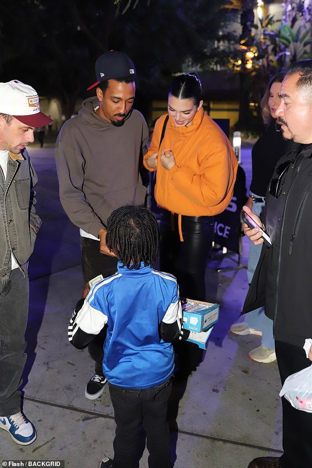 A treat: Taco looked casual cool on a hoodie, black jeans and a baseball hat and was seen paying for the sweet treat