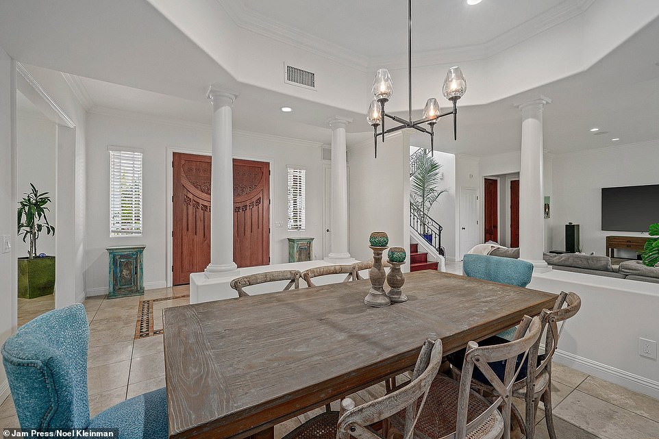 On the ground floor, an airy open-floor plan connects the large living room and formal dining room area with a stellar kitchen, complete with granite counters, a spacious island, custom cabinets, and stainless steel appliances.