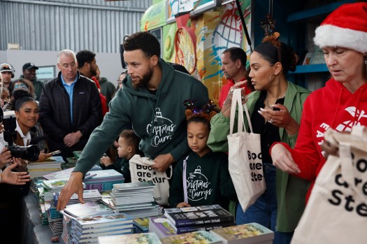 NBA Stephen Curry with wife Ayesha Curry and family hand-out books to participants during the Christmas with the Curry’s Foundation, Eat. Learn. Play., who hosted 500 families at the Christmas party at The Bridge Yard in Oakland, Calif., on Sunday, Dec. 11, 2022. (Josie Lepe for Bay Area News Group) 