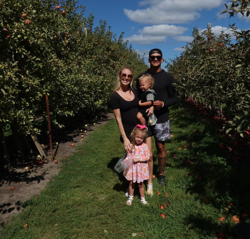 Brittany and Patrick Mahomes with their two kids apple-picking.