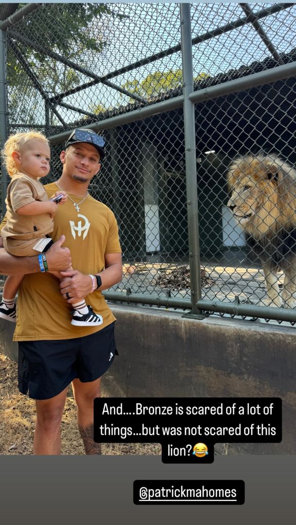 Patrick Mahomes holding son Bronze next to a lion in a photo taken Oct. 10.