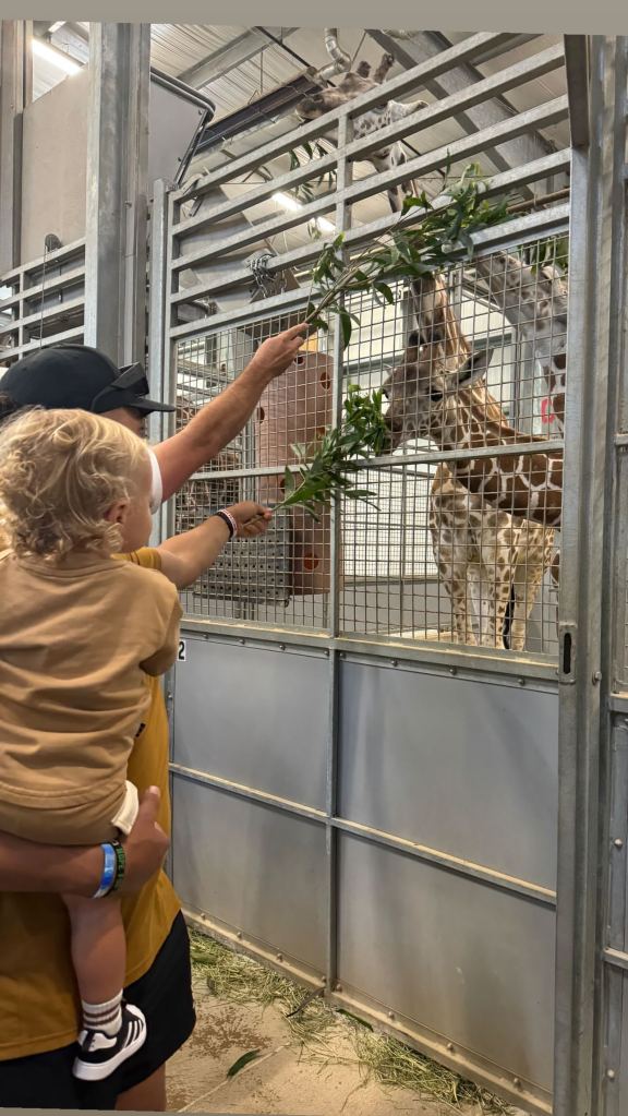 Patrick Mahomes holding son Bronze next to a giraffe in a photo taken Oct. 10.