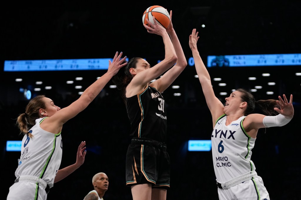 New York Liberty forward Breanna Stewart (30) shoots against Minnesota Lynx forward Bridget Carleton (6) and forward Alanna Smith (8) during the first quarter of Game 5 of the WNBA basketball final series, Sunday, Oct. 20, 2024, in New York.