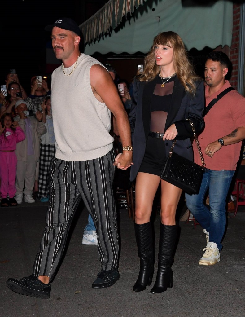 Taylor Swift and Travis Kelce walk hand in hand after dining at Lucali Pizza on Henry Street in Brooklyn, New York.