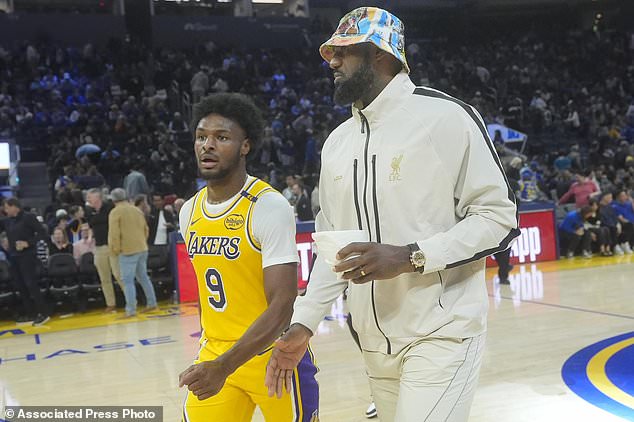 Los Angeles Lakers guard Bronny James (9) walks off the floor with forward LeBron James during halftime of an NBA preseason basketball game against the Golden State Warriors in San Francisco, Friday, Oct. 18, 2024. (AP Photo/Jeff Chiu)